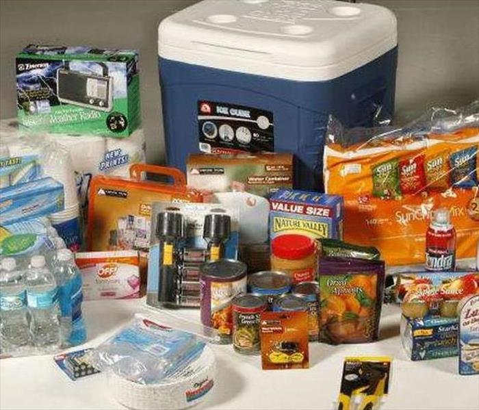 Image of supplies that could be used during a winter storm if you are trapped at home such as a cooler, water, and a radio.