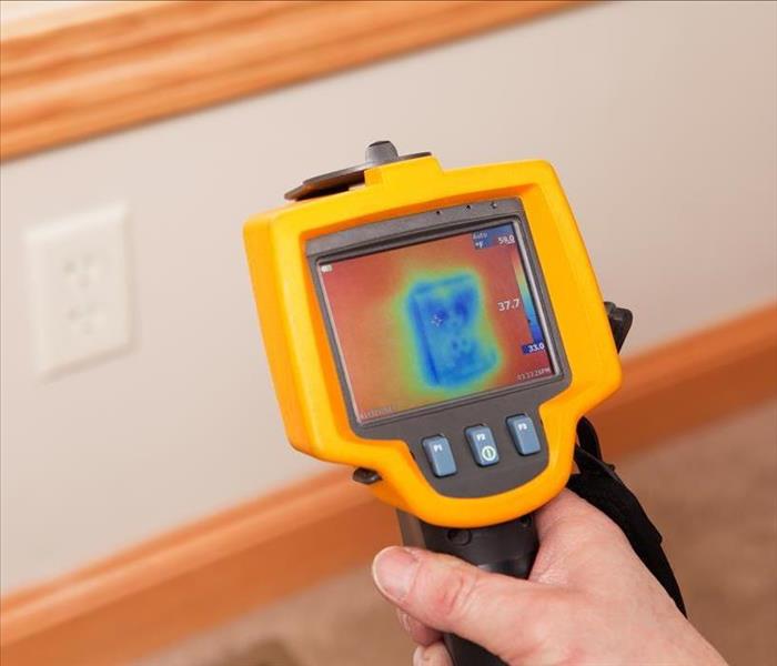 hand-held infrared camera showing image on wall