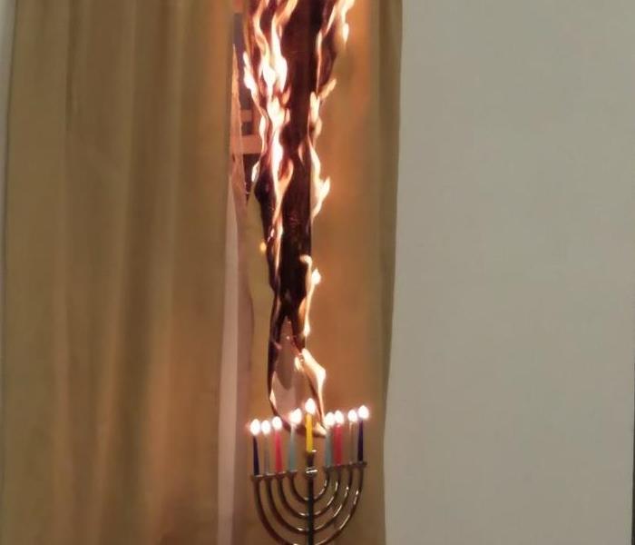 A menorah lights curtains into a blaze during the holiday season