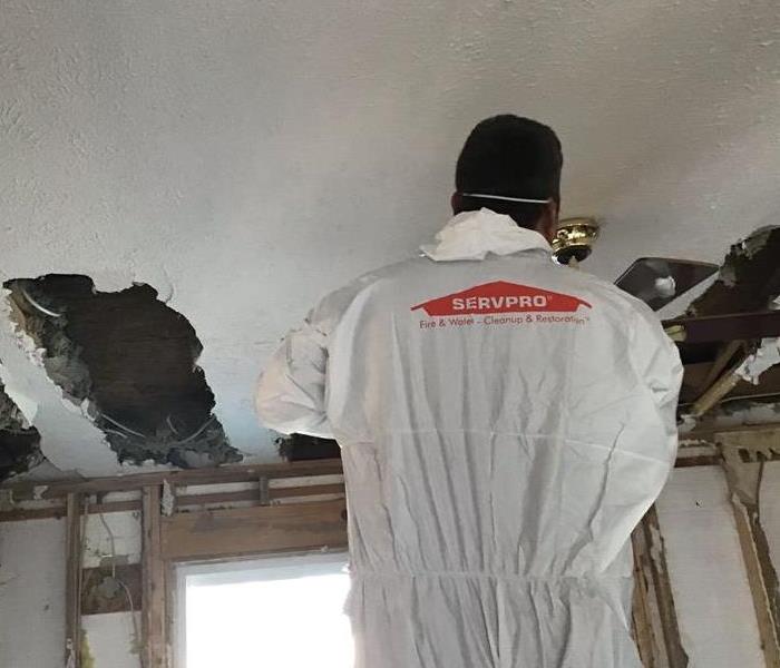 A SERVPRO® Crewmember carefully removes drywall from the water damaged ceiling.