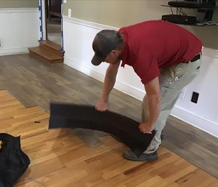 SERVPRO employee removing flooring after a water loss