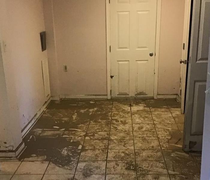 White tile foyer with sediment and dirt from flooding storms
