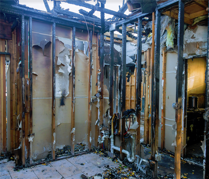 a fire damaged room with debris and soot everywhere